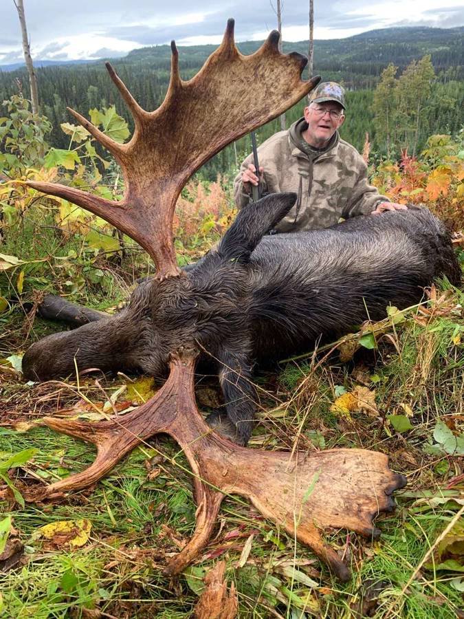 A successful hunter with a large black bear trophy.